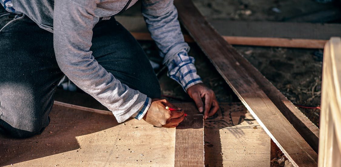 carpenter measuring wood to cut