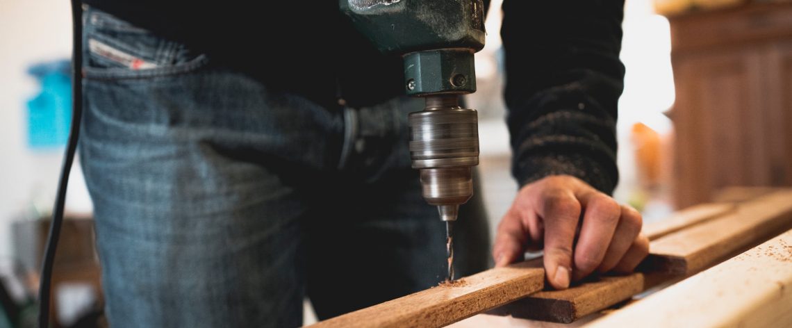 tradie drilling a hole into wood