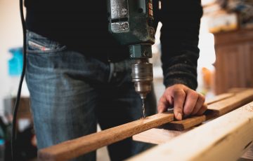 tradie drilling a hole into wood