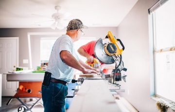 carpenter cutting wood under table saw