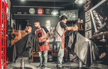 Two barbers cutting hair in a barber shop