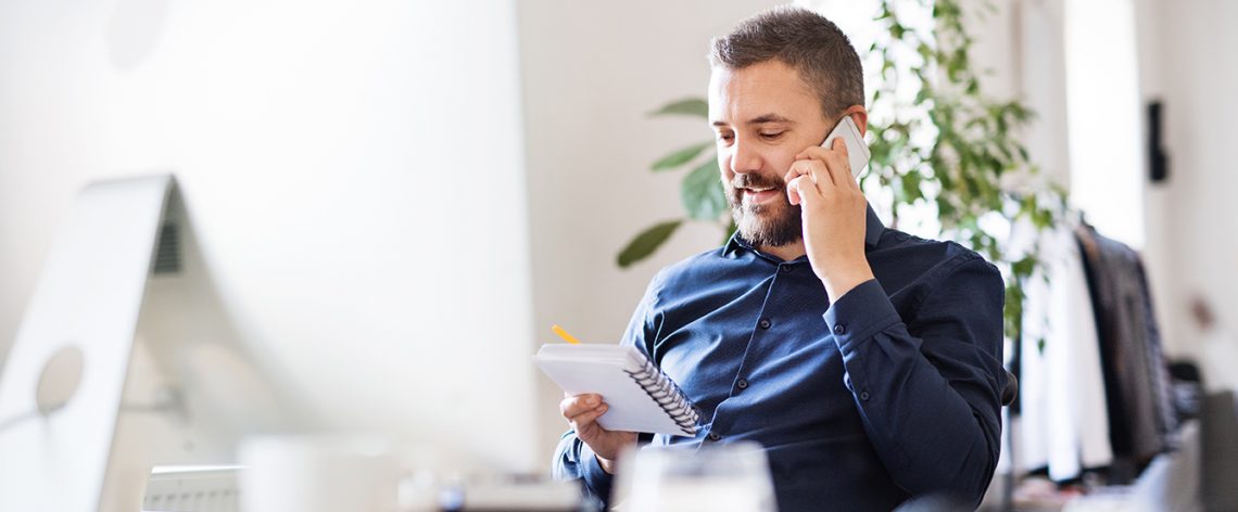 Man on a call reading from a notepad