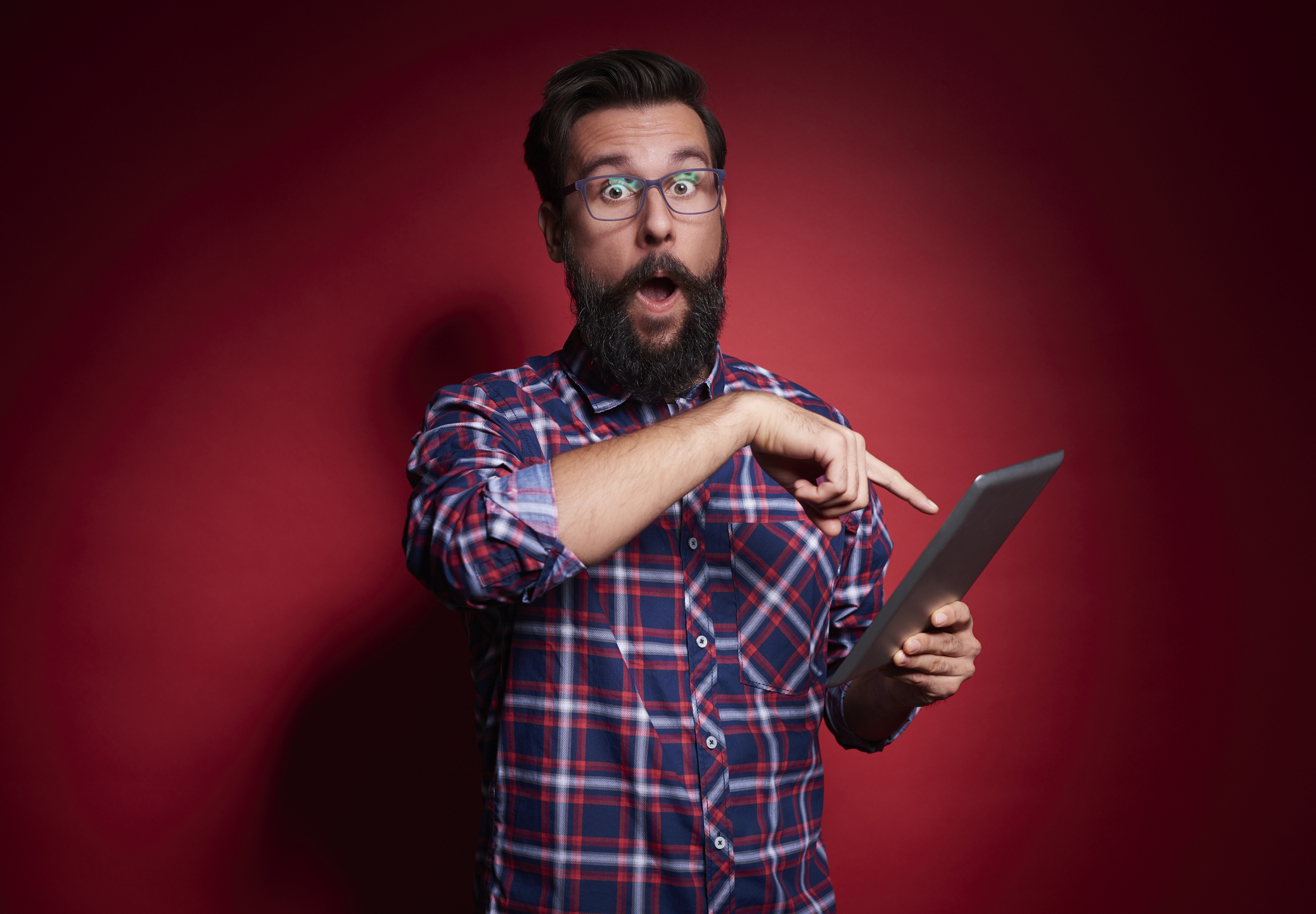 Surprised man pointing at ipad