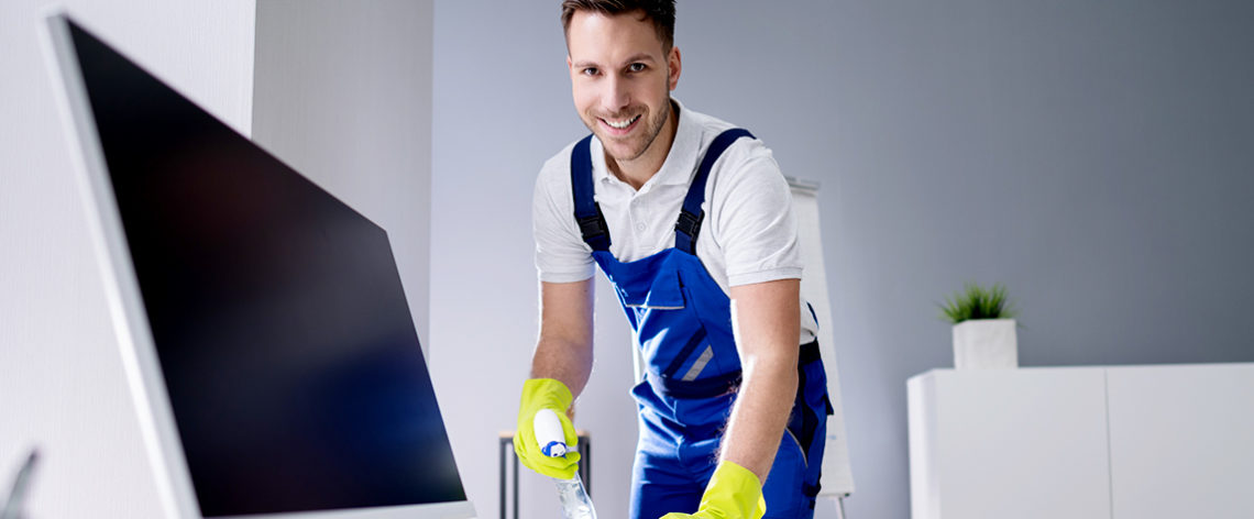 cleaner cleaning the desk and looking at the camera