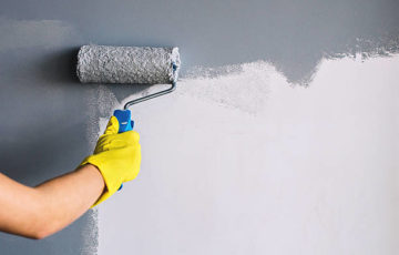 painter painting a wall in grey